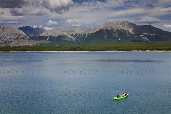 Family in green canoe with father fishing in Lower Kananaskis Lake