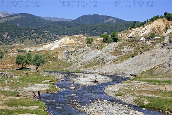 Nomad children washing in river near semi-nomad settlement in the mountains of Eastern Anatolia