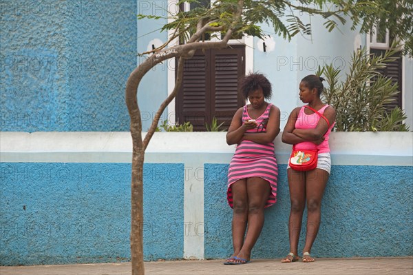 Two Creole women with cell phone in the capital city Esparagos on the island of Sal