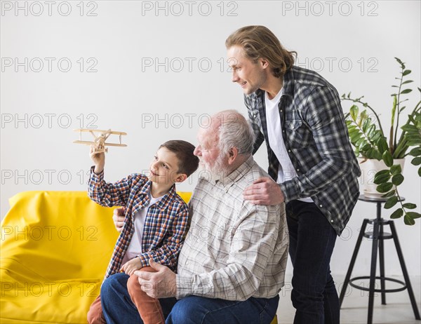 Men different generations looking toy plane