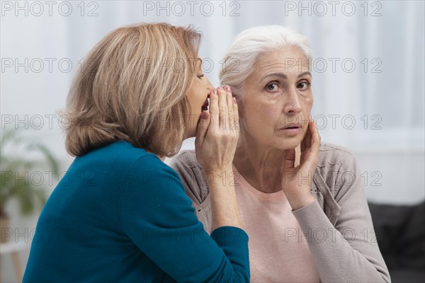 Portrait mature women whispering