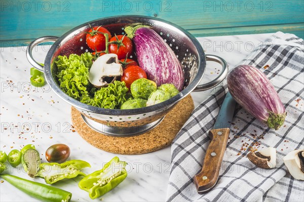 Various fresh vegetables colander marble surface