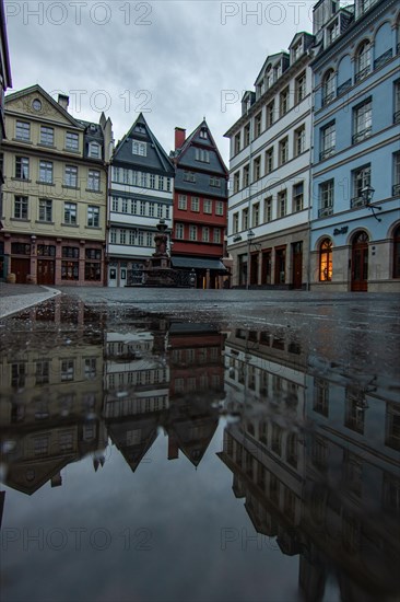 Reflection in a puddle between a historic city centre. Cityscape at the Roemer and the historic houses and streets. Cityscape in Frankfurt am Main