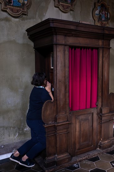 Woman Confesses Inside a Beautiful Church of San Carpoforo with Sunlight in Bissone