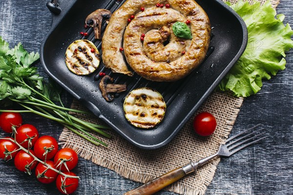 Grill pan with delicious spiral grilled sausage vegetable