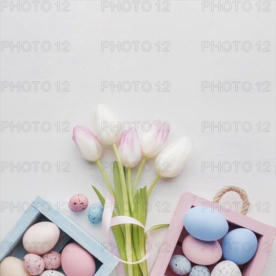 Top view cute boxes with colorful easter eggs bouquet tulips