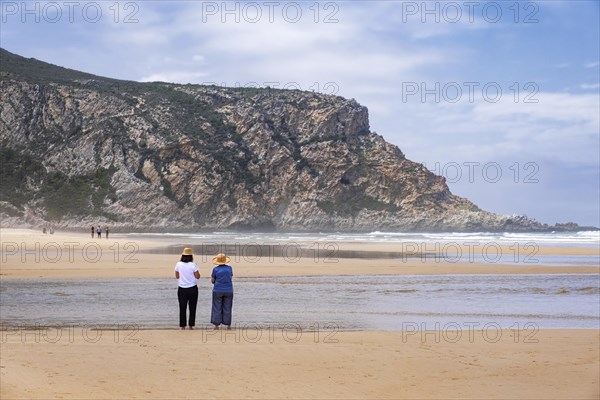 Tourists walking on Nature's Valley sandy beach in the Tsitsikamma Section of the Garden Route National Park