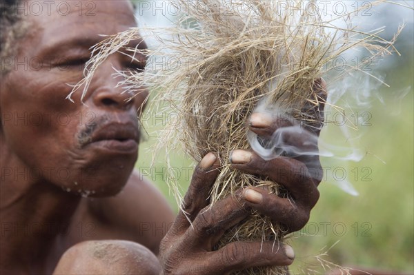 Bushman making fire in the Kalahari desert near Ghanzi