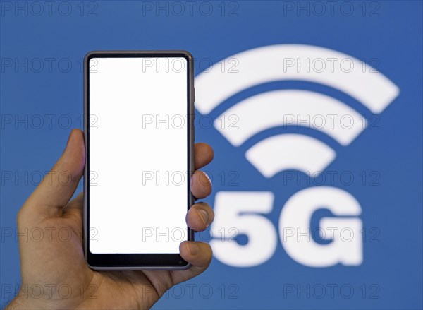 Hand holding phone with 5g symbol background