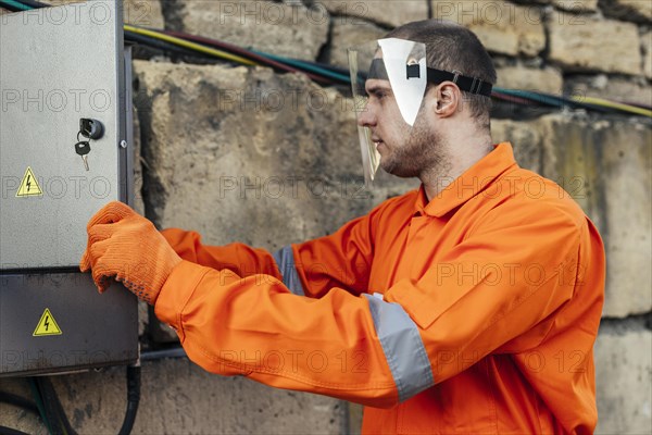 Side view electrician uniform with protective gloves face shield