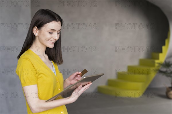 Side view woman holding tablet credit card