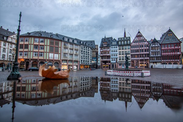 Reflection in a puddle between a historic city centre. Cityscape at the Roemer and the historic houses and streets. Cityscape in Frankfurt am Main