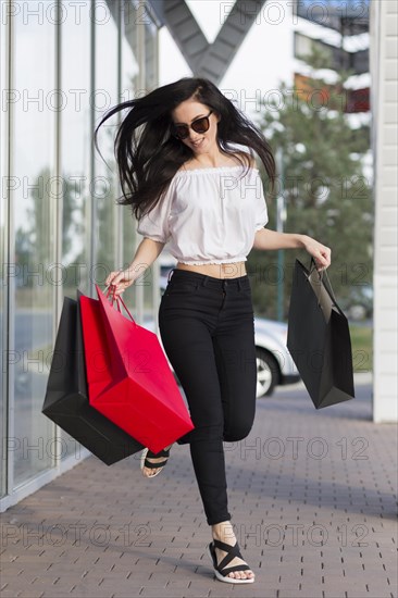 Woman jumping with shopping bags