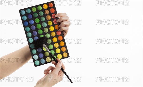 Hands holding make up brush with palette copy space