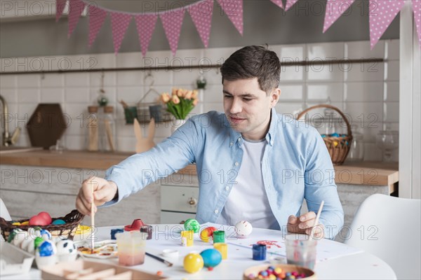 Portrait father painting eggs easter