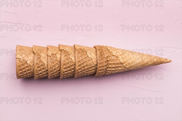Stacked waffle cones pink background