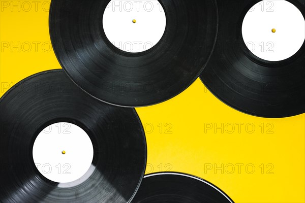 Overhead view vinyl records yellow background