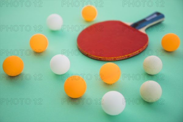 Ping pong balls wooden racket turquoise background