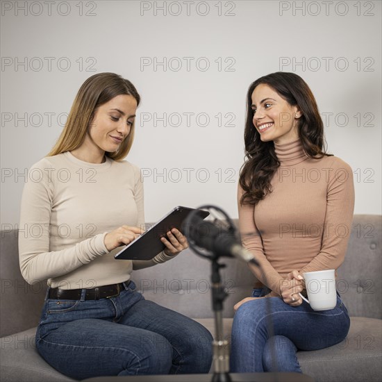 Two women radio studio with microphone tablet