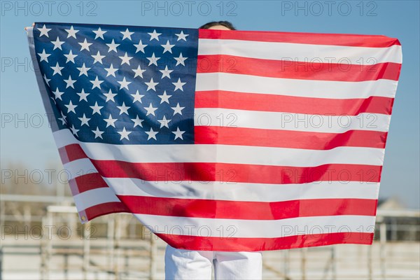 Woman holding big usa flag herself