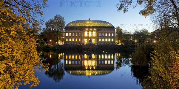 The Staendehaus K21 is reflected in the Kaiserteich in autumn in the evening