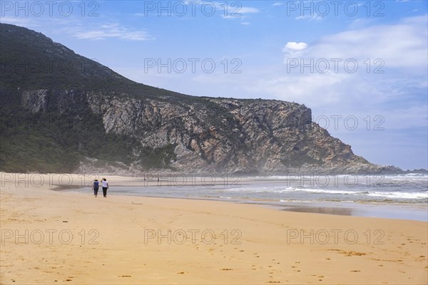 Tourists walking on Nature's Valley sandy beach in the Tsitsikamma Section of the Garden Route National Park