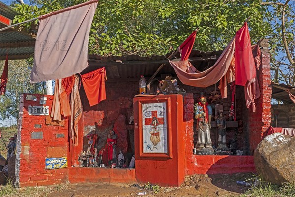 Traditional red roadside shrine to folk saint Gauchito Gil