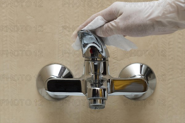 Hand with glove disinfecting faucet