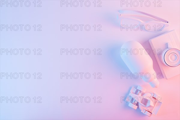Overhead view lightbulb spectacles formula one car camera against pink backdrop with blue light