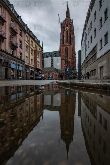 Reflection in a puddle between a historic city centre. Cityscape at the Roemer and the historic houses and streets. Cityscape in Frankfurt am Main