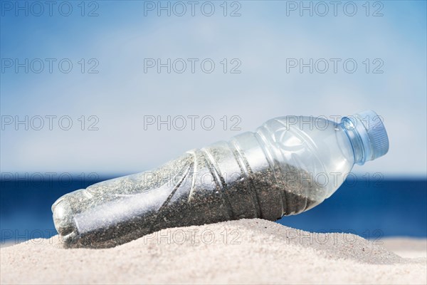 Front view plastic bottle beach with sand