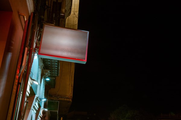 Low angle view illuminated billboard residential building against sky