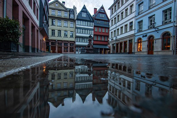 Reflection in a puddle between a historic city centre. Cityscape at the Roemer and the historic houses and streets. Cityscape in Frankfurt am Main