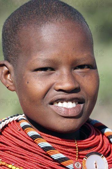 Portrait of young Turkana woman in traditional red clothing in northwest Kenya