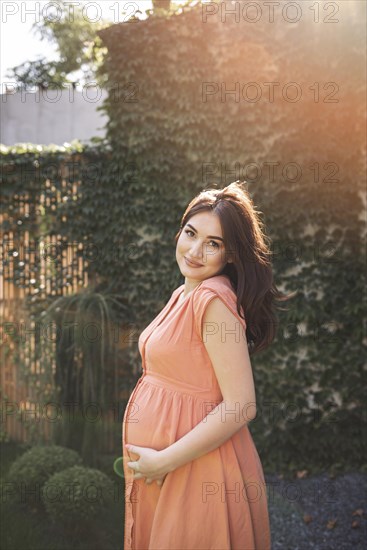 Medium shot pregnant woman posing outdoors