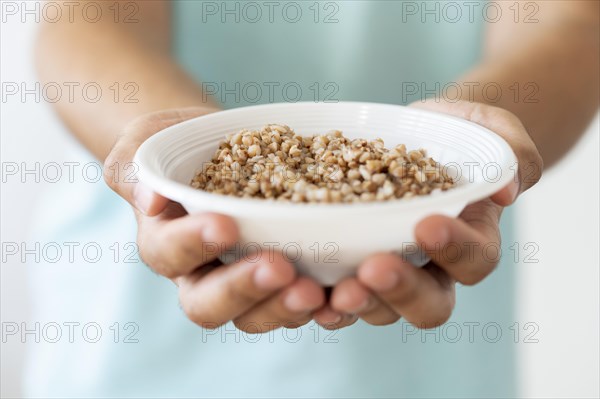 Needy person holding bowl food