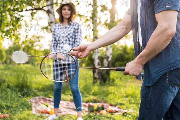 Young couple playing badminton picnic