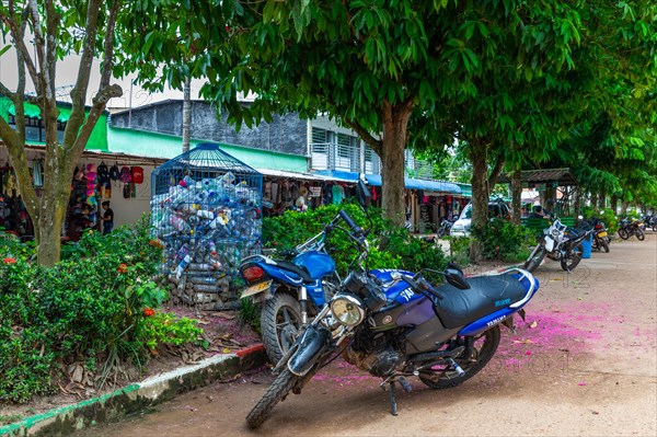 Motorbike in front of container for empty pastik bottles