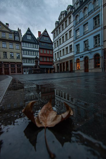 Reflection in a puddle between a historic city centre. Cityscape at the Roemer and the historic houses and streets. Cityscape in Frankfurt am Main