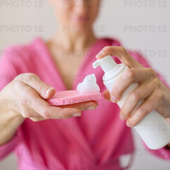 Front view woman using face cleanser