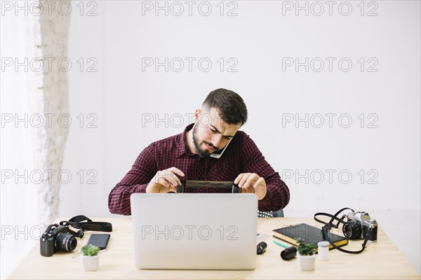Grapher using laptop while talking by mobile phone