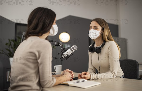 Smiley women doing radio with medical masks