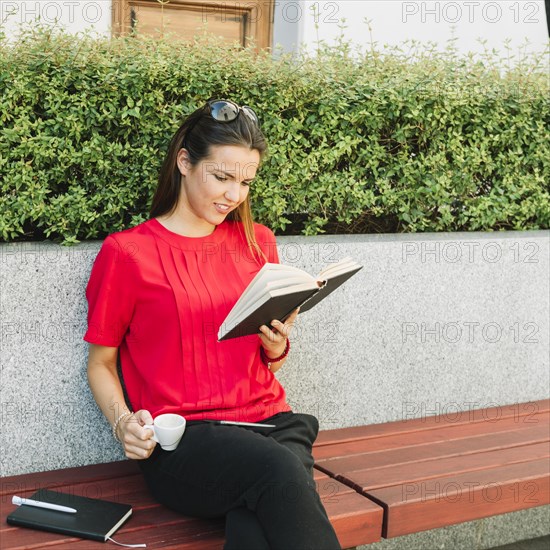 Woman with cup coffee reading book