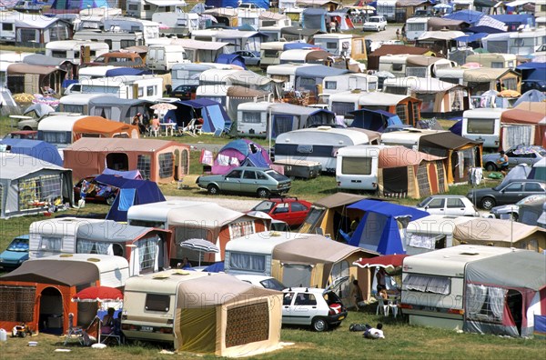 Caravans and camping tents at busy campsite in the dunes along the North Sea coast during the summer holidays