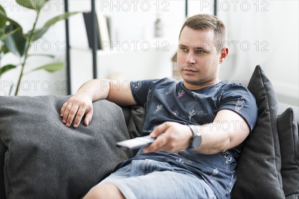Mid adult man sitting sofa watching tv