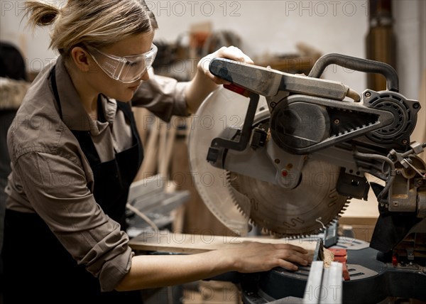 Side view female carpenter with safety glasses tool