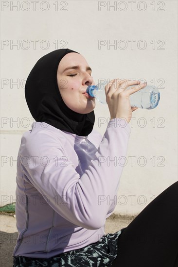 Woman with purple jacket drinking water