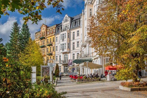 Typical row of houses with street cafe by the autumnal spa park