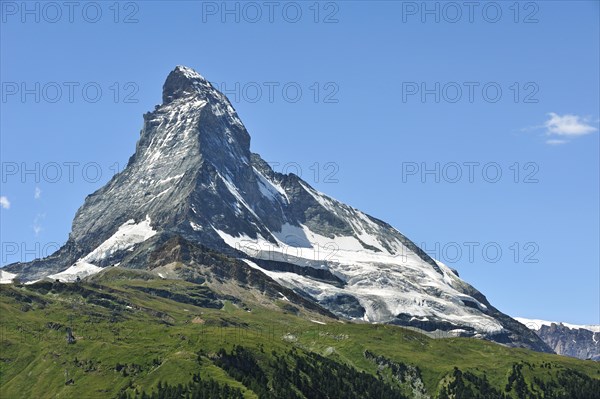 View over the Matterhorn mountain with alpine meadows and pine forests near Zermatt