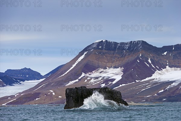 Wave crashing into huge boulder in Burgerbukta